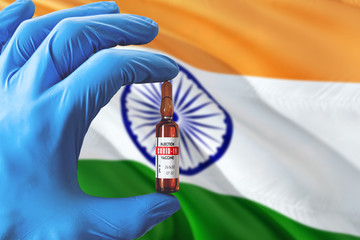 India flag with Coronavirus Covid-19 concept. Doctor with blue protection medical gloves holding a vaccine bottle. Epidemic Virus, Cov-19, Corona virus outbreaking.