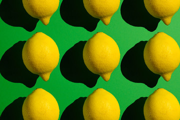 Yellow lemon on a green background with hard light