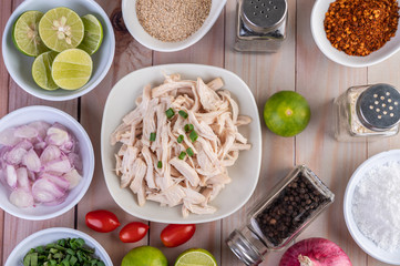 Boiled chicken cut into pieces in a white dish on a wooden table.