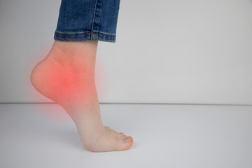 Woman suffering from heel pain. Inflammation or sprain of the tendon in the foot, heel spur,...