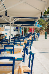 cafe on the beach, Romantic  restaurant with blue chairs and tables under palm leaves