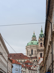 St Nicholas Church, also called Kostel Svateho Mikulase, in Prague, Czech Republic, with its iconic dome seen from nearby streets with typical baroque facade. It's one of main landmarks