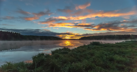 Summer dawn on a pond with fog