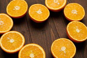 dark wooden background with blank space for text and fresh sliced orange fruits as a frame - natural and healthy food.