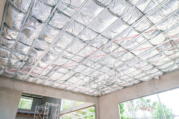 Home under construction install heat insulate the ceiling in the form of foil.