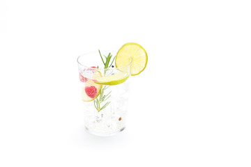 tonic jar with ice and a slice of lemon with some fruits on a white background