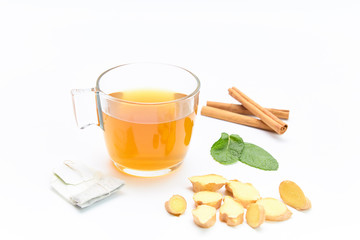 cup of green tea next to a bag, ginger, mint and cinnamon