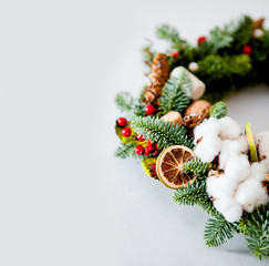 close-up elements of Christmas wreath with red shiny beads with flowers of cotton and slices of dried oranges