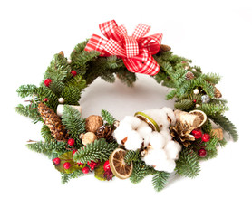 Fototapeta na wymiar Christmas wreath with red shiny beads with flowers of cotton and