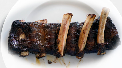 ready to eat - grilled spareribs from a beef on a white plate
