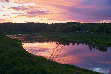 The bright sunset sky is reflected in the river.