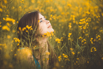 Naklejka premium beautiful romantic girl on blooming rapeseed field enjoying nature, young elegant woman walking, pretty female face, concert freedom, inspiration