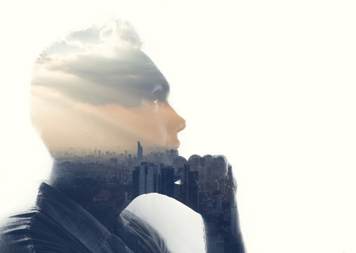 Double exposure portrait of a man in contemplation at sunset time above the city