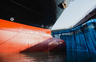 prow of ship moored at floating dry dock in shipyard