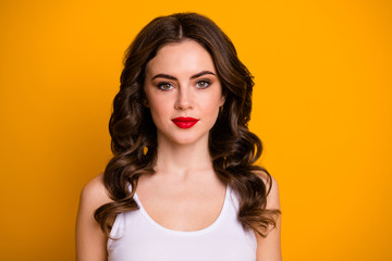 Closeup photo of pretty curly brunette lady red bright lipstick kind facial expression easy-going person good mood wear white casual tank-top isolated yellow color background