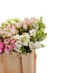 a large armful of white, lilac and pink roses and eustoma flowers in a plastic box