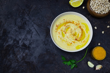 chickpeas hummus with olive oil on a black background