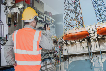 worker in oil rig drilling plant with walkie-talkie radio Petroleum industry during maintenance and...