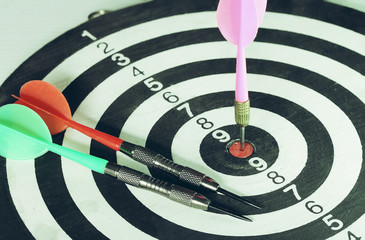 Close up shot of the dart arrow hitting on bull eyes of dartboard to represent that the business...