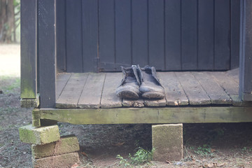 Old boots outside an old wooden house