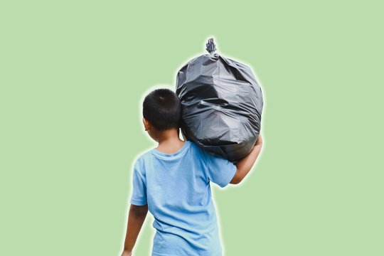 A boy carrying a garbage bag with outer glow light isolated on green background