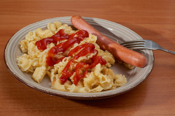 Italian pasta with sausages in tomato sauce with a rustic table background
