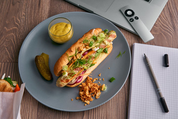 Classic hot dog on the desktop surrounded by modern devices, a computer