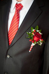 groom's suit close up with a striped tie and buttonhole