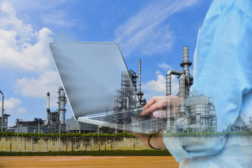 Double exposure worker with note book on oil refinery plant background.