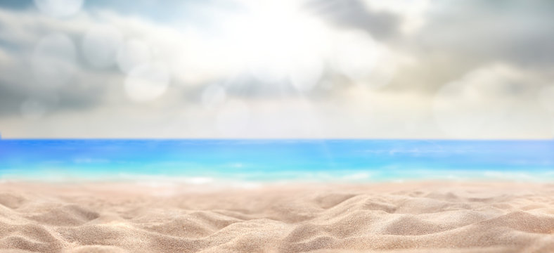 A summer vacation, holiday background of a tropical beach and blue sea and sun breaking through clouds. © Duncan Andison