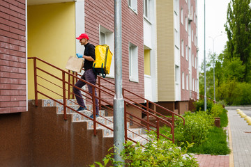 delivery, mail and people concept - happy man delivering food in disposable paper bag to customer home