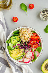 Quinoa salad with fresh vegetables, spinach, green peas, microgreens and sesame seeds in a bowl in a concrete background. Healthy food concept. Vertical orientation. Top view.
