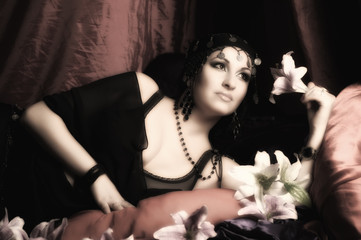 eastern woman in black clothes lies on pillows