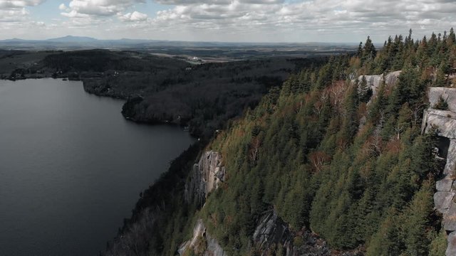 Mount Pinacle With Lush Green Trees Overlooking The Beautiful And Serene Lake In Quebec, Canada At Daytime - aerial drone shot