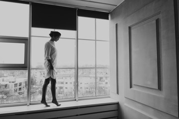 young girl on the background of a bw photo window. Black And White Photo