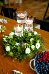 table decorated with candles and a wreath of flowers