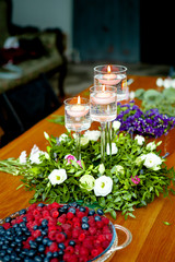 table decorated with candles and a wreath of flowers