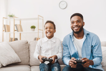 Happy afro dad enjoying video game with his cute daughter © Prostock-studio