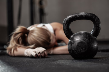 drained female bodybuilder after hard crossfit training at gym