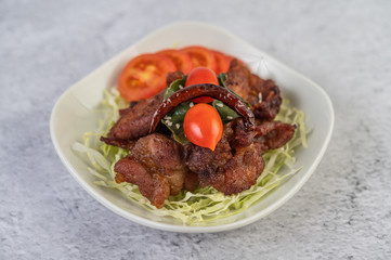 Fried pork topped with sesame placed in a white dish.