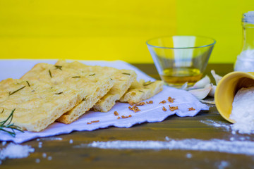 Homemade Italian Focaccia Modenese, with rosemary and olive oil on a rustic wooden background.