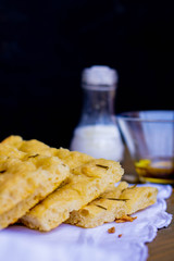 Homemade Italian Focaccia Modenese, with rosemary and olive oil on a rustic wooden background.