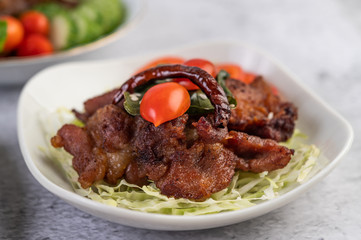 Fried pork topped with sesame placed in a white dish.