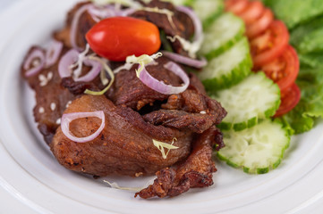 Fried pork topped with sesame placed in a white dish.