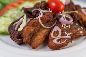 Fried pork topped with sesame placed in a white dish.