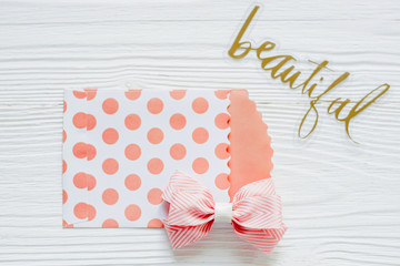 Fototapeta premium A pink bow is placed on a white wooden background