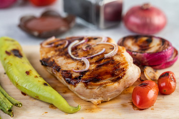 Chicken steak placed on a wooden tray.