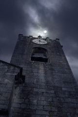 Old bell tower in a cloudy full moon night