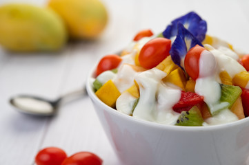 Fruit salad in a bowl on the wooden floor.