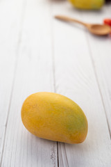 Yellow ripe mangoes laid on the wood floor.
